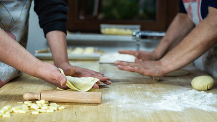 Close-up of woman's hands working the dough to prepare cheese ravioli. Traditional Sardinian cuisine. Homemade.
