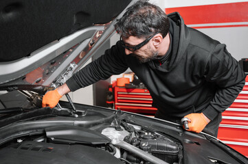 Auto mechanic working and repair on car engine in mechanics garage. Car service. High quality photo