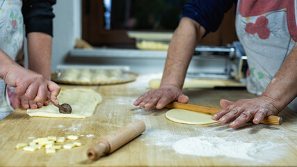 Close-up of woman's hands working the dough to prepare cheese ravioli. Traditional Sardinian...