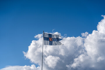 Finland’s flag with the lion flying in the hard wind on a sunny day - 395978611