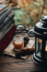 Scandinavian hygge styled Christmas composition. Cozy winter homely scene with candle and sweaters.
