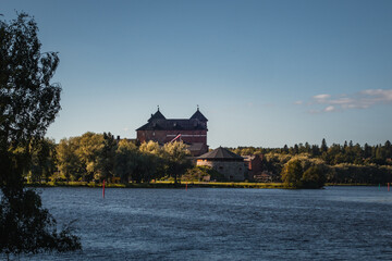 The medieval castle of Hameenlinna in Finland by the lake and forest on a sunny day - 395978861