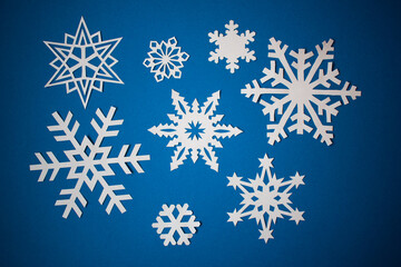 Obraz premium Various paper snowflakes on blue background
