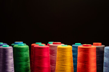 Industrial spools arranged on black background 