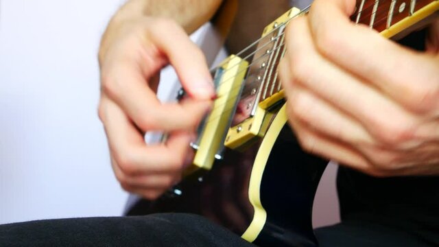 Close-up of a man's hands playing an electric guitar blues solo