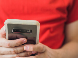 View of man's hands holding a smartphone with copy space