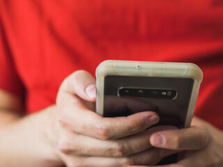 View of man's hands holding a smartphone with copy space