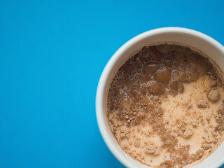 Top view a white mug with blue background. Copy space. Breakfast concept