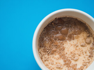 Top view a white mug with blue background. Copy space. Breakfast concept