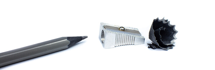 Sharpener and a broken pencil. Shavings and a graphite on white background. Close up photo.