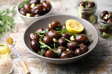Selective focus. Pickled plums in a bowl and jars. Plums with garlic and rosemary. Fermentation of plums. Gourmet appetizer soaked plums.