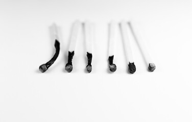 An extinct match in a man's hand. Death and aging concept. Burned matches in a row on a white background. Virus.  Death concept.