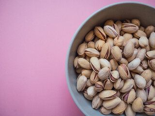 Top view pistachios with pink background. Copy space