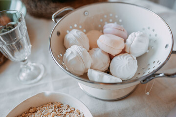 Fototapeta na wymiar Christmas decorations. White and pink marsh-mallows inside white bowl on wooden table.