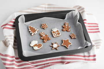 Gingerbread Christmas cookies with glazed sugar icing on baking sheet. Traditional baking