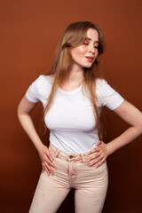 young pretty girl with blond hair posing cheerful on brown background, lifestyle people concept