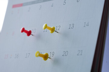Three push pins on calendar.