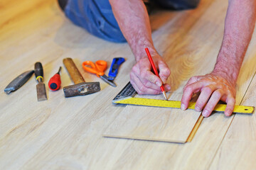 Carpenter's hands mark on the laminate Board. There are tools nearby