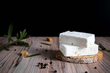 Feta cheese with rusk bread on a wooden background