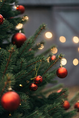 winter holidays, season and luxury concept - close up of red decorations on artificial christmas tree outdoor