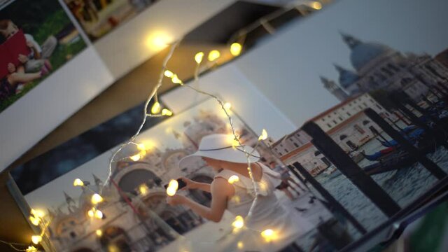 gifts, photo book and Christmas socks on the fireplace in a garland lights