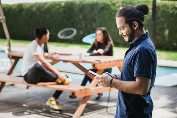 Mexican young businessman holding a smart phone outdoors in Latin America