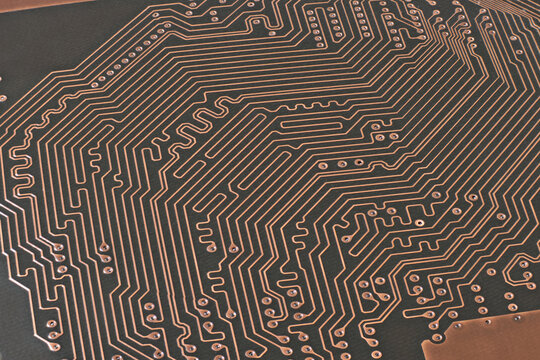 Brown printed circuit board with a lot of traces macro shot with high depth of field. Conductive traces and through-hole vias on pcb.