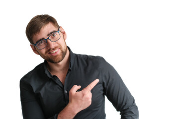 Portrait of a happy handsome bearded glasses businessman in eyeglasses and black shirt pointing finger away over isolated white background