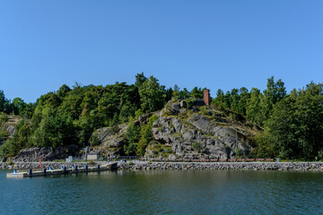 Pier and rocks of small Vallisaari island located between Helsinki and Suomenlinna. Despite small size there are fortifications, buildings, and a record-breaking range of species.