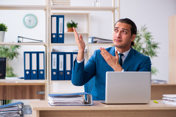 Young handsome employee sitting in the office