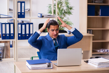 Young handsome employee sitting in the office