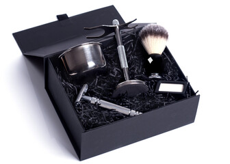 Razor and brush on stand, blades in black gift box on a white background