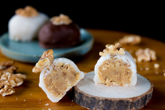Doce camafeu no suporte de madeira. Camafeu cortado ao meio recheado. Camafeu branco recheado.  Sobremesa camafeu. Camafeus com nozes em cima. Close no camafeu