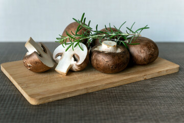 Champignon with brown variety on wooden board.