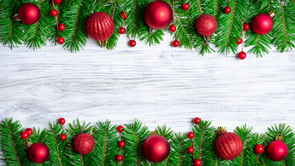Christmas background border with ornaments and pine branches on wood