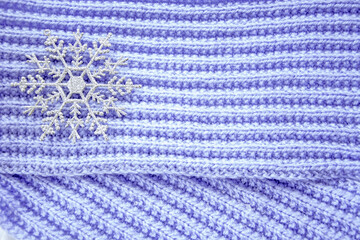 A huge snowflake. Christmas toys in the form of snowflakes lie on a hand-knitted lilac scarf. New year's composition for Christmas.