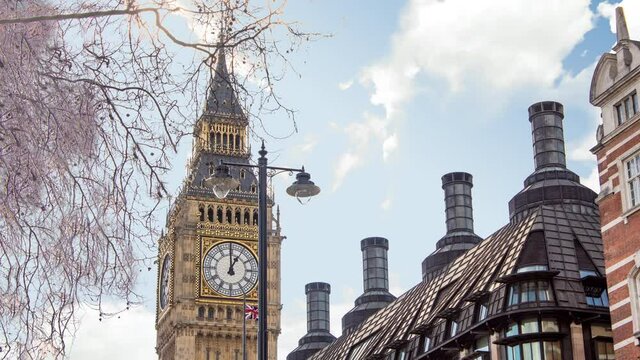 Time lapse of big ben tower or clock during a sunny cloudy day. There is the tower in close up and the clouds in background