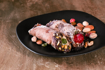 Two cannoli with almonds and pistachio