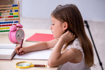 Obraz na płótnie Canvas Small girl preparing for exams at home