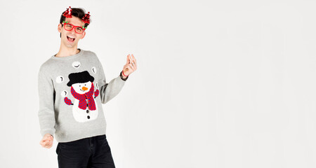 Young dancing man in Christmas sweater with party glasses on white background