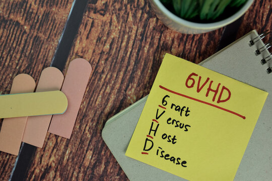 GVHD - Graft Versus Host Disease write on sticky notes isolated on Wooden Table.