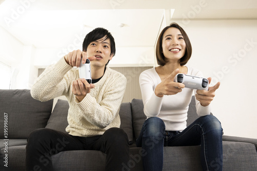 最新ビデオゲームを楽しむカップル 恋人同士でゲームを楽しむ姿 ゲーム機に夢中になる夫婦 Wall Mural Hirota