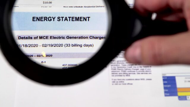 Communal payments. Energy statement sheet close-up. Shooting through a magnifying glass