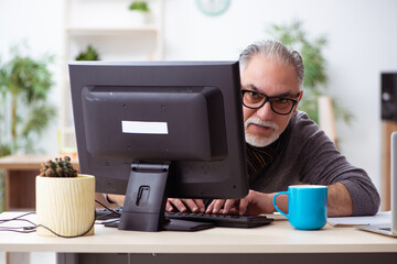 Old male employee working from house during pandemic