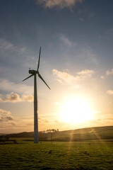 Obraz premium a wind turbine spinning in the sunset providing clean green energy