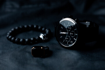 Reloj de pulsera negro elegante sobre fondo negro. Accesorios para hombre.	
