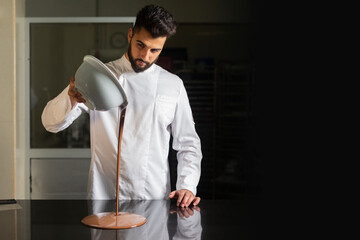 Pastry chef working on tempering chocolate on marble table