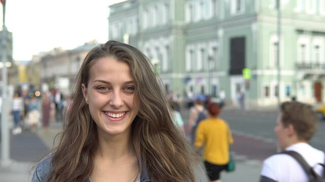 Beautiful girl with a smile on the background of the city