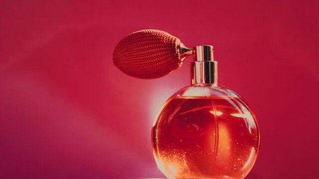 Vintage perfume bottle and shining light flares on red background, glamorous fragrance scent as luxury perfumery product for cosmetic and beauty brand, stock footage