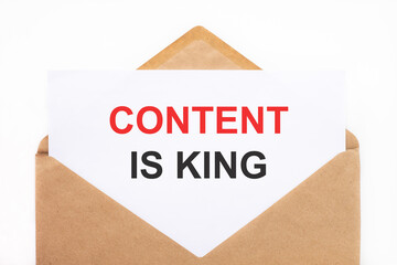 A white sheet with the text content is king lies in an open craft envelope on a white background...